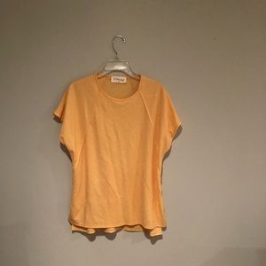 This top is a cantaloupe color. The brand is the Paisley parrot, size medium